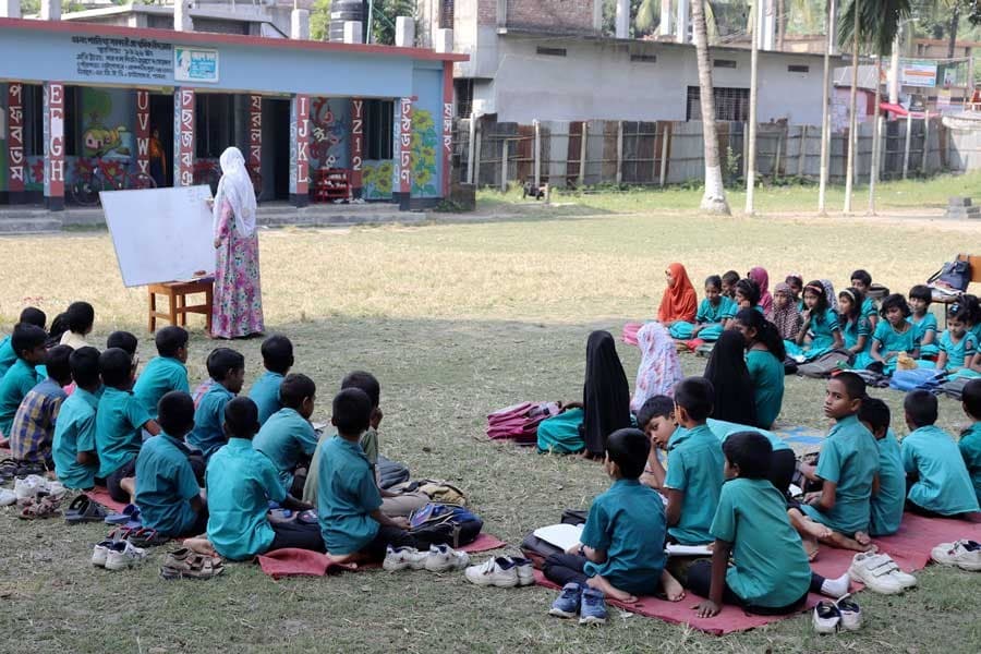 Students take lessons under open sky for shortage of classrooms